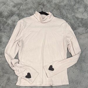 Elegant Cream Turtleneck with Black Heart Details